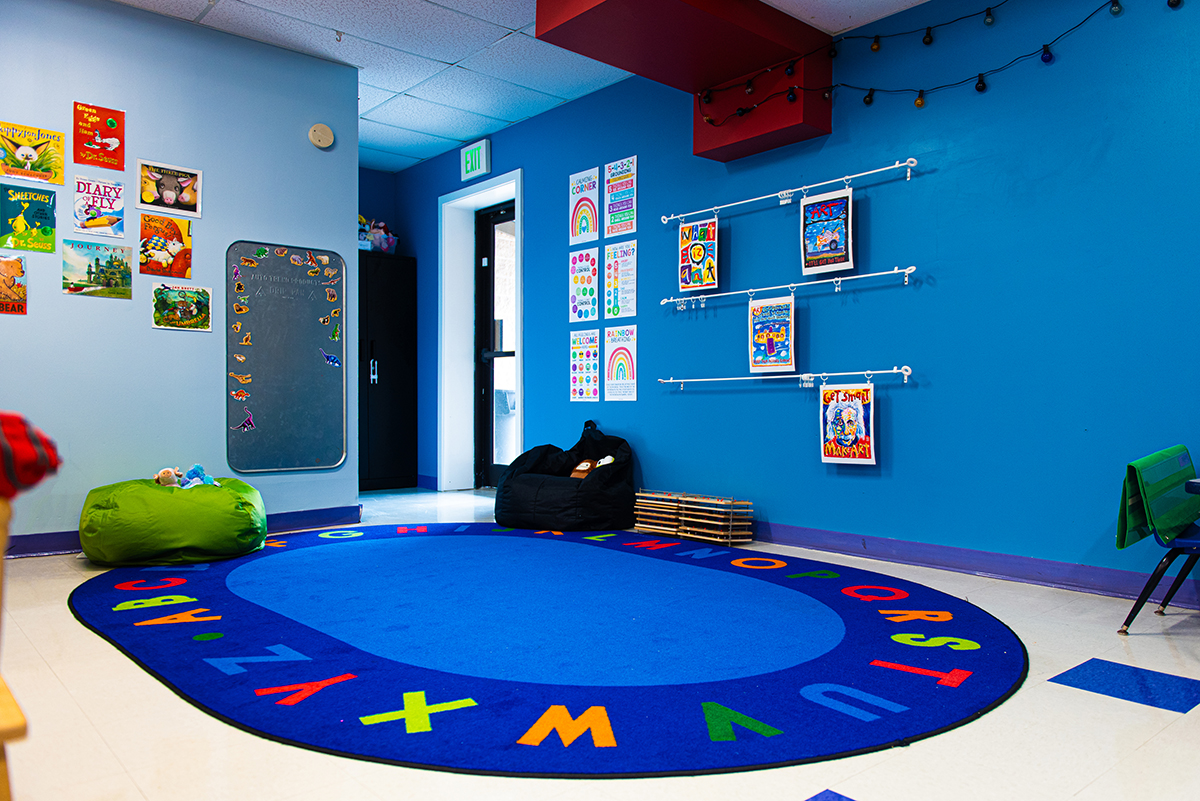 A bright and welcoming preschool classroom at Coppermine, organized with activity stations and colorful decorations to inspire creativity. An empty preschool classroom with colorful tables and chairs, ready for kids to explore and learn.