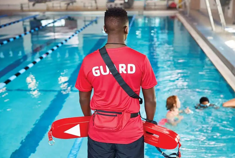 Indoor Outdoor Pool Options at Coppermine. Enjoy aquatics all year round. Image of a lifeguard overseeing happy swimmers in pool