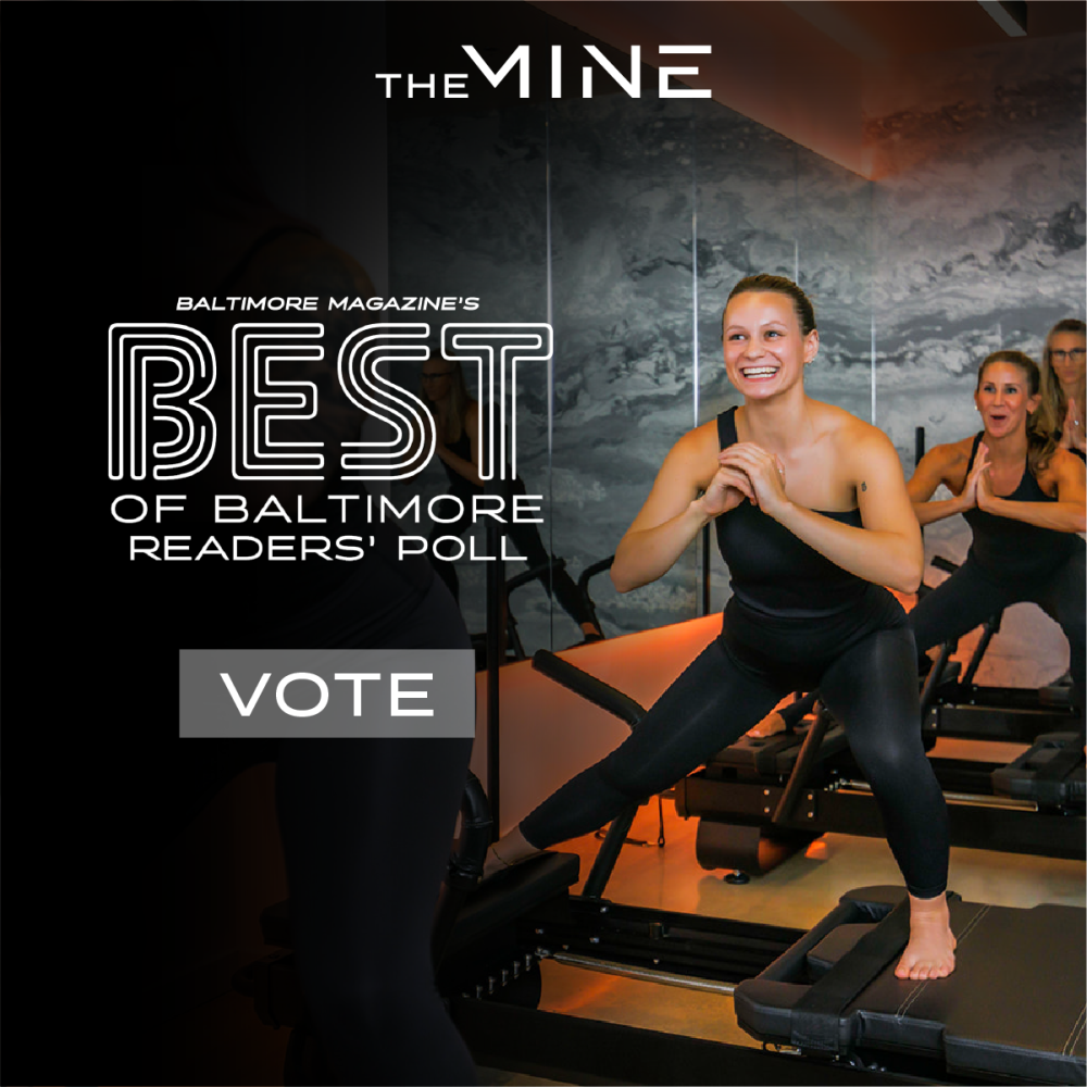 Image of two smiling women on pilates reformers. Text superimposed over image reads: "The Mine, Baltimore Magazine's Best of Baltimore Readers' Poll. Vote"